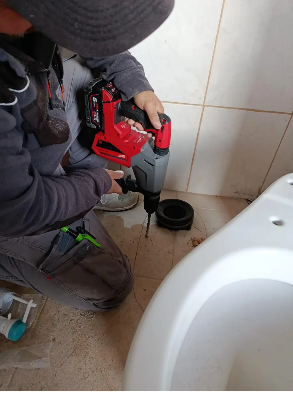 Fontanero de HRVS trabajando con taladro percutor profesional en una reforma de baño en Mallorca